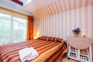 - une chambre avec un lit, un bureau et une fenêtre dans l'établissement Po Jūros Banga, à Palanga