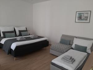 a bedroom with a bed and a couch at Apartmány VIENNA in Mikulov