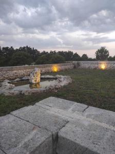 a stone wall with a fountain in a yard at Affitto frassanito in Otranto