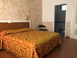 a bedroom with a bed with a orange comforter at Hotel Eden in Padova