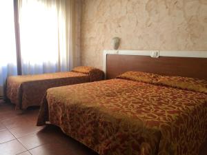 una camera d'albergo con due letti e una finestra di Hotel Eden a Padova