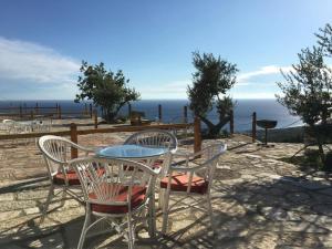 a table and chairs with a view of the ocean at Rahoni Park & Suites in Dhërmi
