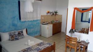 a kitchen with a bed and a table and a refrigerator at Studios Avra in Akhladherí