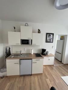 una cocina con armarios blancos y fregadero en Apartment 2 Gäste en Schörfling