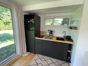uma pequena cozinha com um lavatório e um frigorífico em Ferienhaus Aalglatt am Deich, 250 m zum Strand em Dierhagen