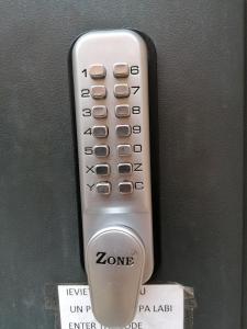 un mando a distancia está sujeto a una pared en Bella Riga Hotel with Self-Check in en Riga