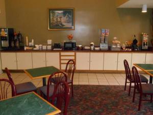 a restaurant with tables and chairs and a counter at AmeriStay Inn St Joseph in Saint Joseph
