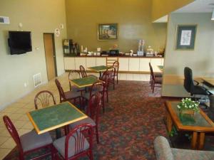 a restaurant with tables and chairs and a bar at AmeriStay Inn St Joseph in Saint Joseph