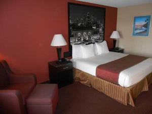 a hotel room with a bed and a chair at AmeriStay Inn St Joseph in Saint Joseph