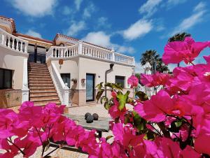 uma casa com flores cor-de-rosa em frente em CASANTILVIA heated pool paradise em Adeje