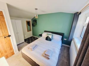 1 dormitorio con 1 cama con 2 toallas en The Annexe at Tenniside • Private Garden • Hot Tub, en Perranporth