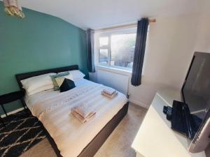 1 dormitorio con 1 cama con toallas en The Annexe at Tenniside • Private Garden • Hot Tub, en Perranporth