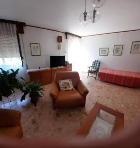 Casa Elena في Amaroni: غرفة معيشة مع أريكة وكرسي