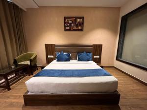a bedroom with a large bed with blue pillows at AH1 Hotel in Amritsar