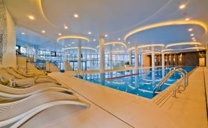 a large swimming pool on a cruise ship at Aqua Resort Apartments - Pool & Sauna, Aqua Park in Kołobrzeg
