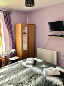 a bedroom with a bed and a flat screen tv at Heddfan (Place of Peace) in Llanboidy