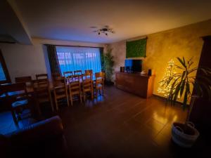 a dining room with a table and chairs and a television at Vila Alex in Tăşnad