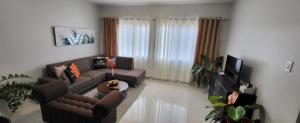ein Wohnzimmer mit Sofa und Fernseher in der Unterkunft Phamz Unit in Bacolod City