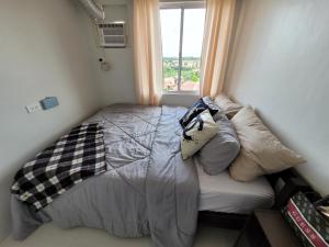 ein kleines Schlafzimmer mit einem Bett und einem Fenster in der Unterkunft Phamz Unit in Bacolod City