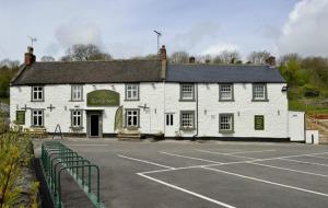 a large white building with a parking lot in front of it at Chatterbox Cottage in Wirksworth
