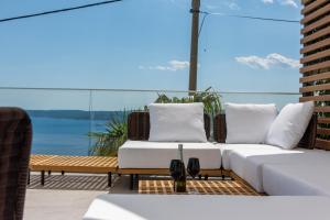un patio con mobili bianchi e vista sull'acqua di Villa Laurynn with Roof Top Spa and Pool a Crikvenica