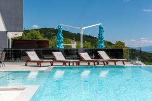 una piscina con sedie a sdraio accanto alla piscina di Villa Laurynn with Roof Top Spa and Pool a Crikvenica