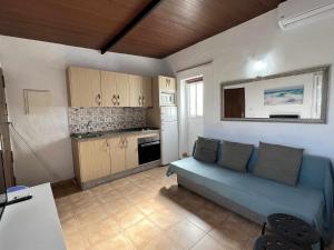 salon z niebieską kanapą i kuchnią w obiekcie Casita cerca de la playa para 2 personas w Kadyksie