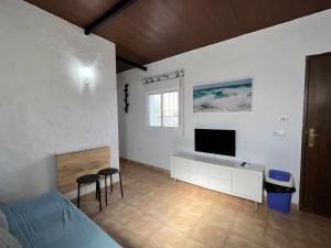 sypialnia z łóżkiem i telewizorem na ścianie w obiekcie Casita cerca de la playa para 2 personas w Kadyksie