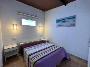 mała sypialnia z łóżkiem i oknem w obiekcie Casita cerca de la playa para 2 personas w Kadyksie
