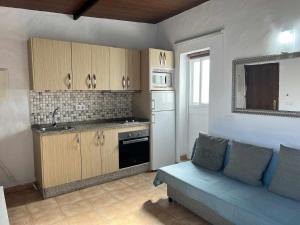 Il comprend un salon avec un canapé et une cuisine. dans l'établissement Casita cerca de la playa para 2 personas, à Cadix