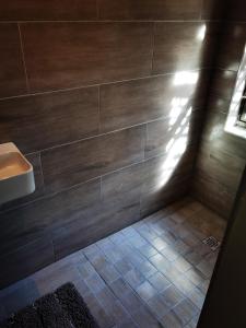 a bathroom with a sink and a tile floor at Calla—Cottage in Ballito