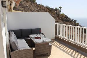a patio with a couch and a table on a balcony at Casa Romantica de Balcon de Amadores in Amadores