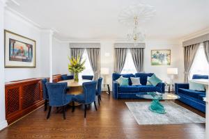 كارلتون كورت مايفير في لندن: غرفة معيشة مع أريكة زرقاء وطاولة