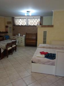 een kamer met 2 bedden, een tafel en een keuken bij Casa nettuno in Nettuno