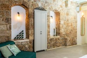 um quarto com um armário branco numa parede de pedra em Jozefin em Acre