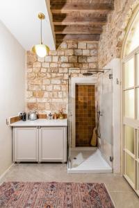 a bathroom with a sink and a shower at Jozefin in ‘Akko