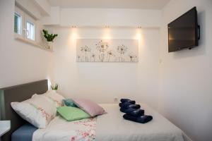 ein Bett mit zwei Kissen und einem TV in einem Zimmer in der Unterkunft Apartment 7 in Novi Vinodolski