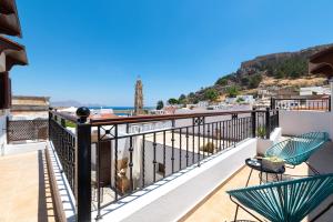 a balcony with two chairs and a view of the ocean at Lindos Luxury Belfry Apartment in Líndos