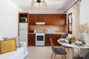 una cucina con divano e tavolo in una camera di Lindos Luxury Belfry Apartment a Líndos