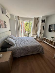 a bedroom with a bed and a large window at Luxury Estudio Malaga Centro in Málaga