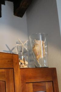 um armário de madeira com dois vasos de vidro em cima em Romantik, charming house em Trieste
