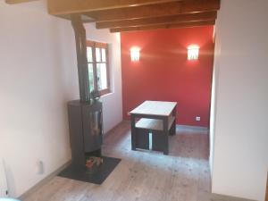 Habitación con mesa y estufa de leña. en Chalet Le Tyrolien, au coeur du Boréon, en Saint-Martin-Vésubie