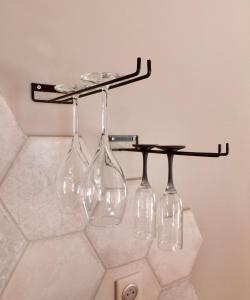 a wine rack with four wine glasses on it at La Suite Côté Pool-House Piscine, Sauna & Jacuzzi privatifs in Istres