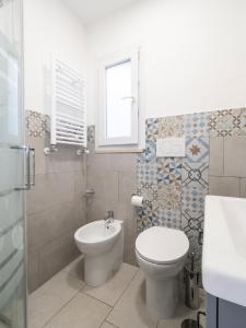 ein Bad mit einem WC, einem Waschbecken und einem Fenster in der Unterkunft Luminoso Appartamento sul Lago - Lake Court in Anguillara Sabazia