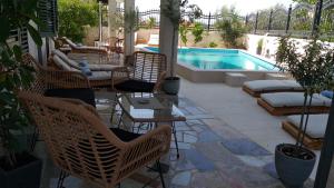 um pátio com cadeiras, uma mesa e uma piscina em Villa Mira Trogir em Trogir
