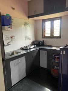 een keuken met een wastafel en een aanrecht bij Haven Homes in Yelahanka