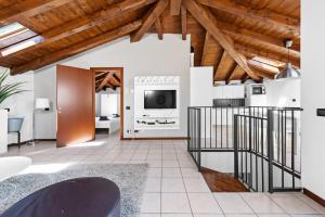ein Wohnzimmer mit Holzdecken und einem TV in der Unterkunft CasaCamelia 35, 3 BDRM with view Lake Como in Acquaseria