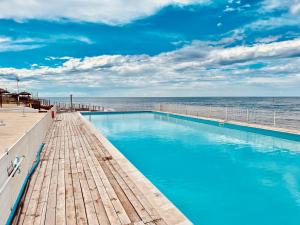 a swimming pool with the ocean in the background at Baia Sangiorgio Hotel & Beach Club in Bari