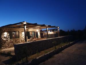 a small stone house at night with a person sitting in front at Robinson in Tisno