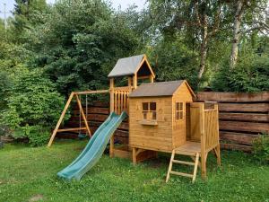 a wooden play set with a slide and a playground at Nad Strumieniem in Cisna